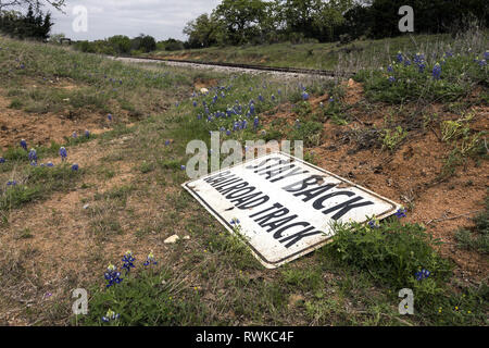 Aufenthalt zurück Eisenbahn Zeichen auf dem Boden im Hill Country, Texas, USA Stockfoto