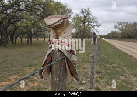 Texas cowboy Boot mit der Oberseite nach unten auf den ländlichen Zaun in der Nähe der Straße Stockfoto