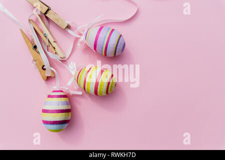 Viele Ostereier im trendigen Pink Pastel Hintergrund. Eier sind von Hand gezeichnet. Flach Stil. Blick von oben auf die Ostereier in verschiedenen Mustern gefärbt. Verschiedene Stockfoto