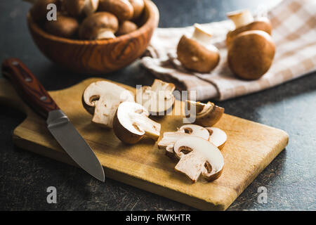 Frisch geschnittenen champignon Pilze auf Schneidebrett. Stockfoto