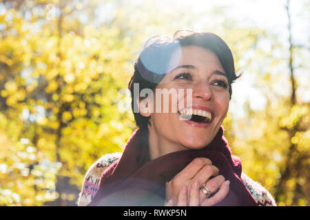 Lächelnde Frau im herbstlichen Wald Stockfoto