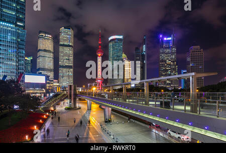 Skyline von Pudong mit Oriental Pearl Tower und erhöhten Laufsteg bei Nacht, Shanghai, China Stockfoto