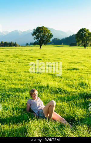 Frau liegend auf Gras im Hinterland, Sonthofen, Bayern, Deutschland Stockfoto