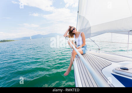 Junge Frau Segeln auf dem Chiemsee, Porträt, Bayern, Deutschland Stockfoto