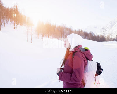 Junge Frau in Strick hut mit Blick auf Schnee Landschaft bedeckt, Alpe Ciamporino, Piemont, Italien Stockfoto