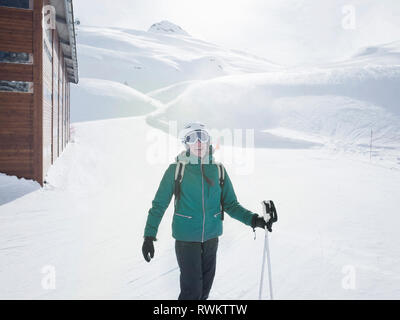 Junge Frau Skifahrer das Tragen von Helm und Skibrille im Schnee lachen Landschaft, Porträt, Alpe Ciamporino, Piemont, Italien Stockfoto