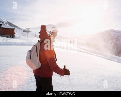 Junge Frau Skifahrer das Tragen von Helm und Skibrille in der schneebedeckten Landschaft, Alpe Ciamporino, Piemont, Italien Stockfoto