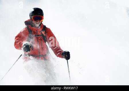 Männliche Skifahrer im Pulverschnee am Berghang Alpe-d'Huez, Rhône-Alpes, Frankreich Stockfoto