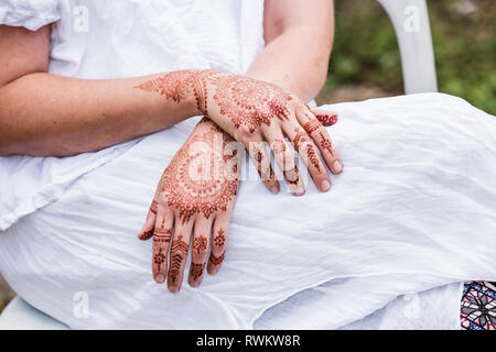 Frau in weißem Kleid mit Henna Tattoo auf Händen Stockfoto