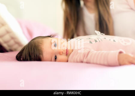 Babymädchen im Bett liegend Stockfoto