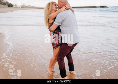 Paar zu umarmen und küssen am Strand Stockfoto