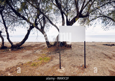 Leer, leeres weißes Schild am Strand in der Nähe des Meeres auf einem Meer Hintergrund Stockfoto