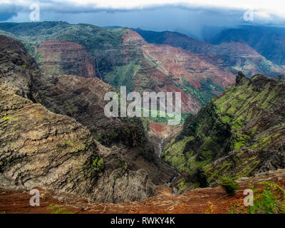 Spektakuläre Sicht auf den Waimea Canyon State Park an einem bewölkten Tag mit Wasserfall und Fluss, Kauai, Hawaii Stockfoto