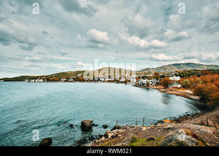 Moody Ansicht von Gumusluk Bucht und das Dorf in Bodrum, Mugla, Türkei an einem trüben Wintertag. Schöne ruhige See, Wiese und Himmel Landschaft. Stockfoto