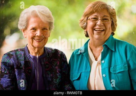 Ältere Frau mit einem Sauerstoff Nase Schlauch (Katheter) und eine reife Frauen lächeln, als sie für ein Portrait zusammen stellen. Stockfoto