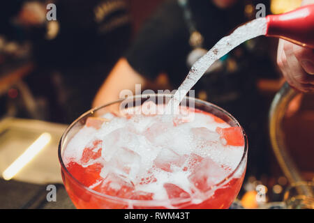 Eis im Sommer erfrischende Limonade mit roten Beeren, Minze, Zitrone, und viele verschiedene fruti in großen Glasflasche Stockfoto