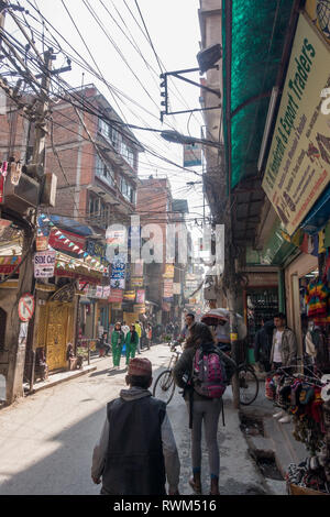 Hektik in den Straßen von Kathmandu, Nepal, wie Einheimische und Touristen in den engen Gassen gemischt. Stockfoto