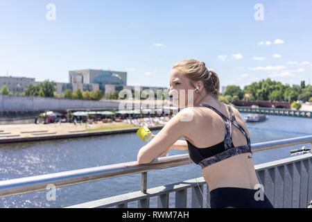 Junge Frau unter Bruch von Übung in der Stadt, Berlin, Deutschland Stockfoto