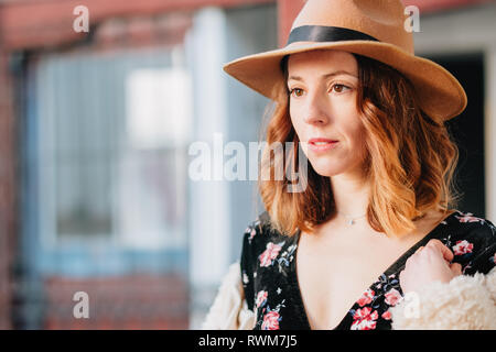 Positive attraktive junge Dame im Kleid mit Hut weg schauen Stockfoto