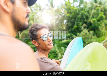 Männer mit Surfbrettern auf der Seilbrücke, Pagudpud, Ilocos Norte, Philippinen Stockfoto