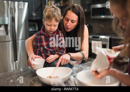 Kinder helfen der Mutter in der Küche Stockfoto