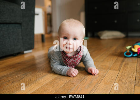 Baby Boy kriechen auf Holzboden Stockfoto