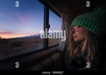 Frau Warmhalten im Wohnmobil in Wüste, Sierra Nevada, Bishop, Kalifornien, USA Stockfoto