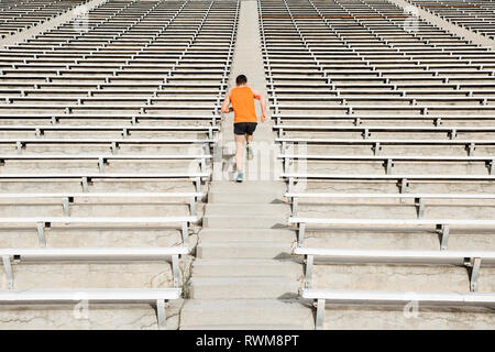 Junge männliche Läufer oben laufen Stadion Treppe, Rückansicht