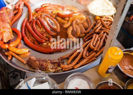 Gebratene Wurst aus Schweinefleisch kochen auf große Pfanne bei Open Street Market - Traditionelle serbische Street Food. Stockfoto