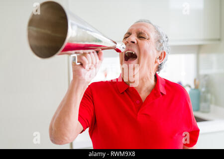 Älterer Mann shouthing durch vintage Metall Megaphon aufgeregt Stockfoto