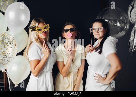 Brautjunfer tragen lustige Masken mit Braid posing Stockfoto