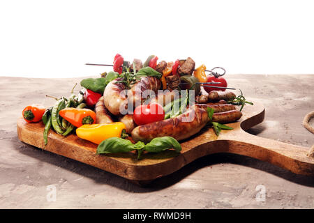 Verschiedene köstliche gegrillte Fleisch mit Gemüse auf einem Grill und gegrilltem Schweinefleisch oder Shish Kebab am Spieß mit Gemüse. Stockfoto