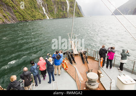 Touristen in einem Boot im Milford Sound, Neuseeland Stockfoto