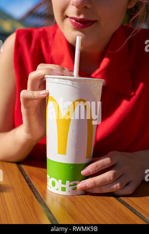 KALININGRAD, Russland - ca. September 2018: Junge Frau mit pappbecher von Coca-Cola bei McDonald's Restaurant. Stockfoto