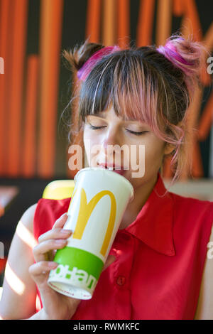 KALININGRAD, Russland - ca. September 2018: Junge Frau getränke Coca-Cola, McDonald's Restaurant. Stockfoto