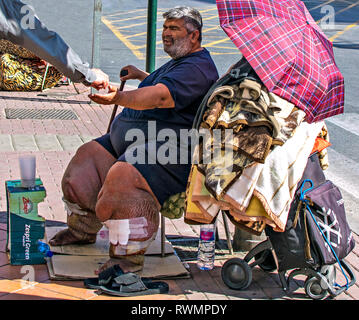 Murcia/Spanien - März 4 - 2019: Schlechte ungesunde Menschen betteln um Almosen in der Straße von Murcia, Spanien. Mann gibt Geld für die Armen. Stockfoto