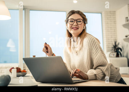 Freundlich lächelnde Frau in super Stimmung am Morgen Stockfoto