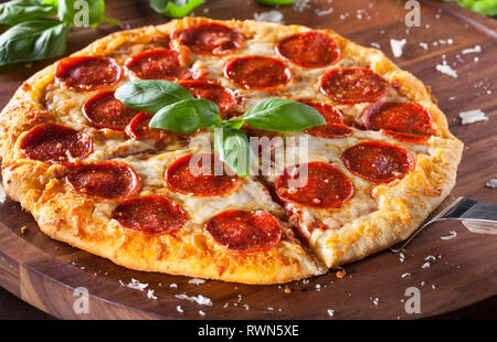 Frischer, heißer homemae Pepperoni Pizza mit Käse Späne Stockfoto