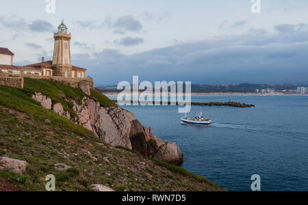 Fischerboot bei Sonnenuntergang Eingabe, Segeln vor dem Leuchtturm von St. Juan, in den Hafen von Avilés, Asturien, Spanien Stockfoto