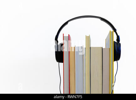Bücher und Kopfhörer. Hörbuch Konzept. Kopfhörer und Bücher auf weißem Hintergrund mit Platz für Ihren Text Stockfoto