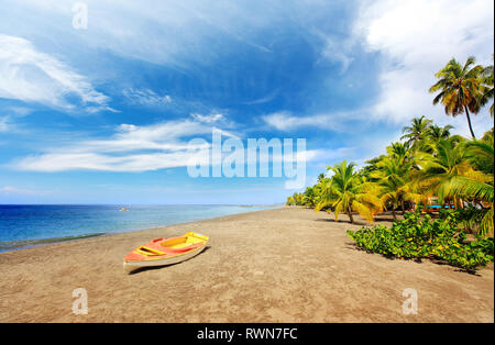 Super Sandstrand in Martinique Island, kleines Boot und Palmen. Exotische Reiseziele in der Karibik. Entdecken Sie Grande Anse Le Coin Strand, Le Carbet Stockfoto