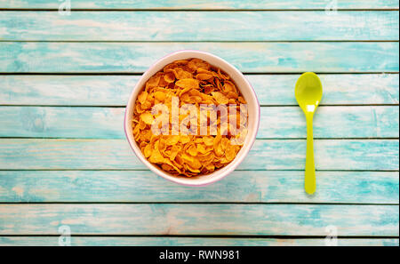 Cornflakes bawl auf einem alten Holztisch. Löffel. Ökologische Lebensmittel Stockfoto