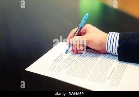 7/8 Nahaufnahme eines Mannes Hand ausfüllen Non Disclosure Agreement (NDA). Lesen und Unterzeichnen Business Konzept Stockfoto