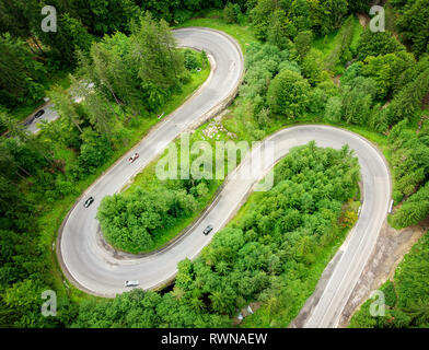 Gebogene kurvenreiche Straße durch den Wald Luftaufnahme. High Mountain Pass in Siebenbürgen, Rumänien. Luftaufnahme Stockfoto