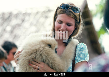 Attraktive junge Frau auf Tour in Thailand durchlöcherte einen Affen zu einem Streichelzoo, Bangkok, 1975 Stockfoto