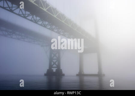 Die Tacoma Narrows Brücken im Nebel von der Wasseroberfläche. Die Brücken erstrecken sich über einen Teil des Puget Sound und verbinden Tacoma mit dem Oly... Stockfoto