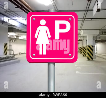Die rosa Zeichen für parkende Autos nur für Frauen im öffentlichen Parkhaus. Parkplatz nur für die Dame an der leeren öffentlichen Parkplatz. Stockfoto