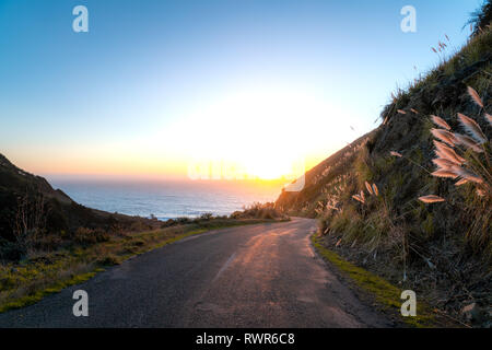 Big Sur, Kalifornien - kurvenreiche Straße führt Sie die küstennahen Hügeln auf den Pazifischen Ozean und den Sonnenuntergang. Stockfoto