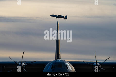 Eine A-10 Thunderbolt II C fliegt über eine C-130J Hercules in Davis-Monthan Air Force Base, Ariz., Feb 26, 2019. Eines der am meisten genutzten Flugzeuge der Luftwaffe Flotte, die A-10 ist speziell für die Unterstützung der nahen Luft und Boden Angriff Missionen gegen gepanzerte Fahrzeuge entwickelt. (U.S. Air Force Foto von älteren Flieger Alexander Koch) Stockfoto