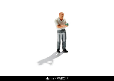 Miniatur sommelier Lesen ein Wein Etikett auf einer Flasche Wein vor dem koppeln Sie es mit Essen auf Weiß mit Schatten und kopieren Raum isoliert Stockfoto